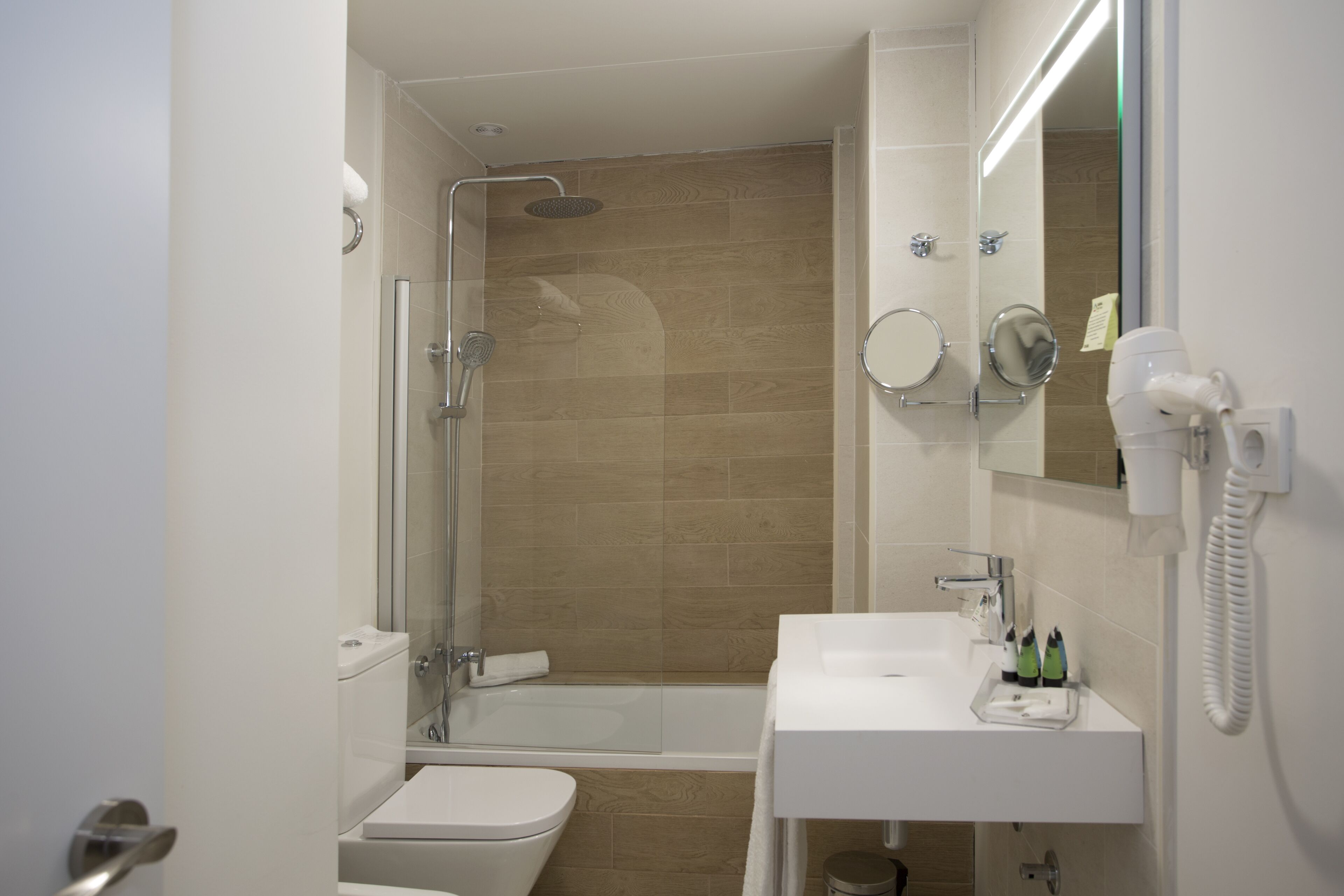 A modern bathroom with a shower, toilet, and sink.