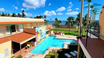 Una piscina al aire libre, sombrillas, tumbonas