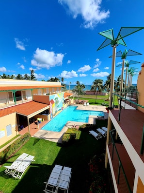 Piscina externa, guarda-sóis, espreguiçadeiras