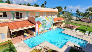 Una piscina al aire libre, sombrillas, tumbonas