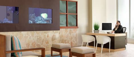A reception area with a stone wall, wooden desk, and seating.