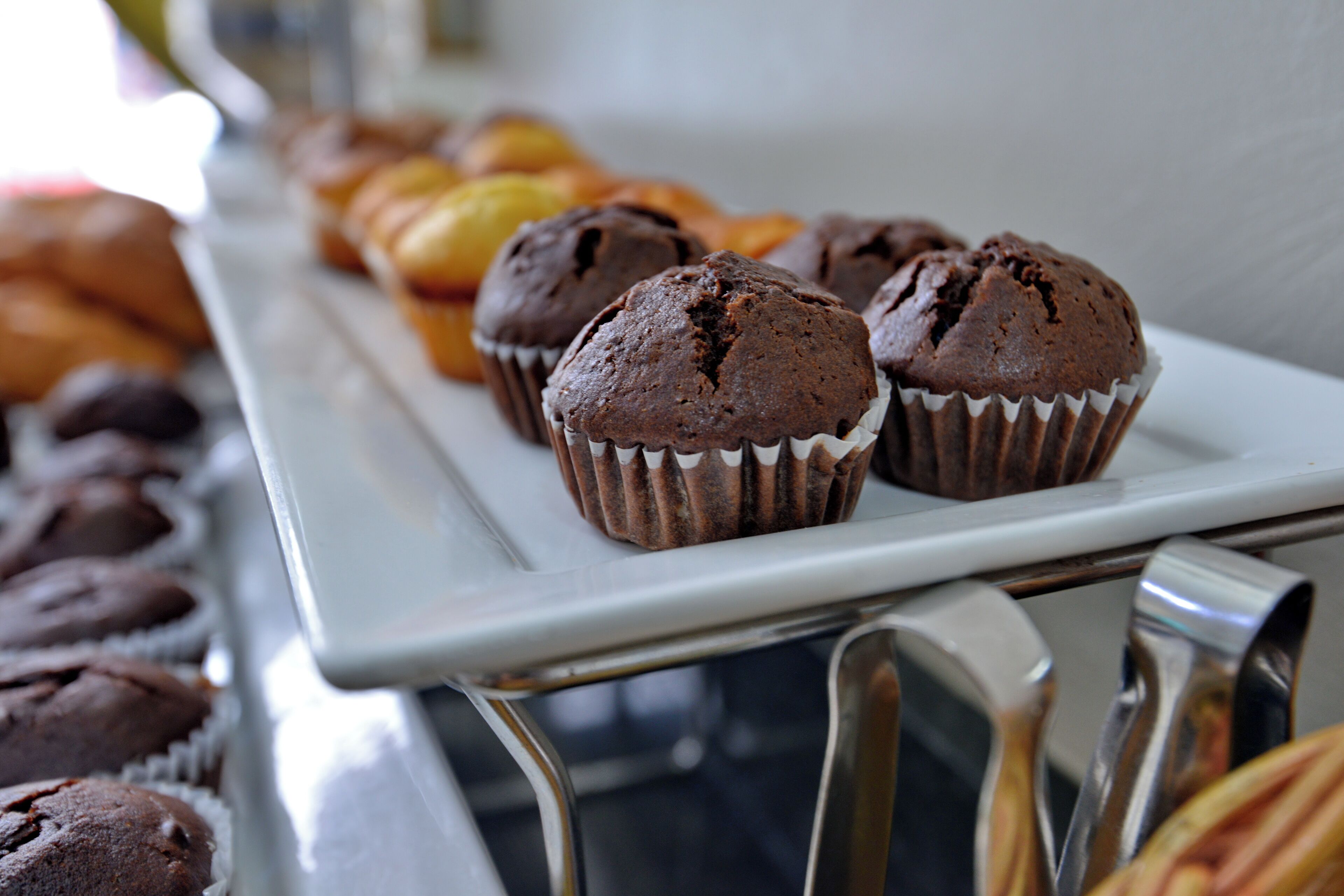 A tray of muffins and pastries on a white surface.