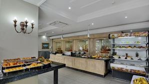 A buffet area with various food items and a central serving counter. - The Balmoral Hotel (Durban)