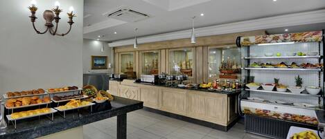 Zona de buffet con diversas opciones de comida y un mostrador central de servicio.
