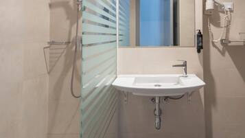 Een moderne badkamer met een douchecabine van glas, een wit wastafelmeubel en een spiegel.