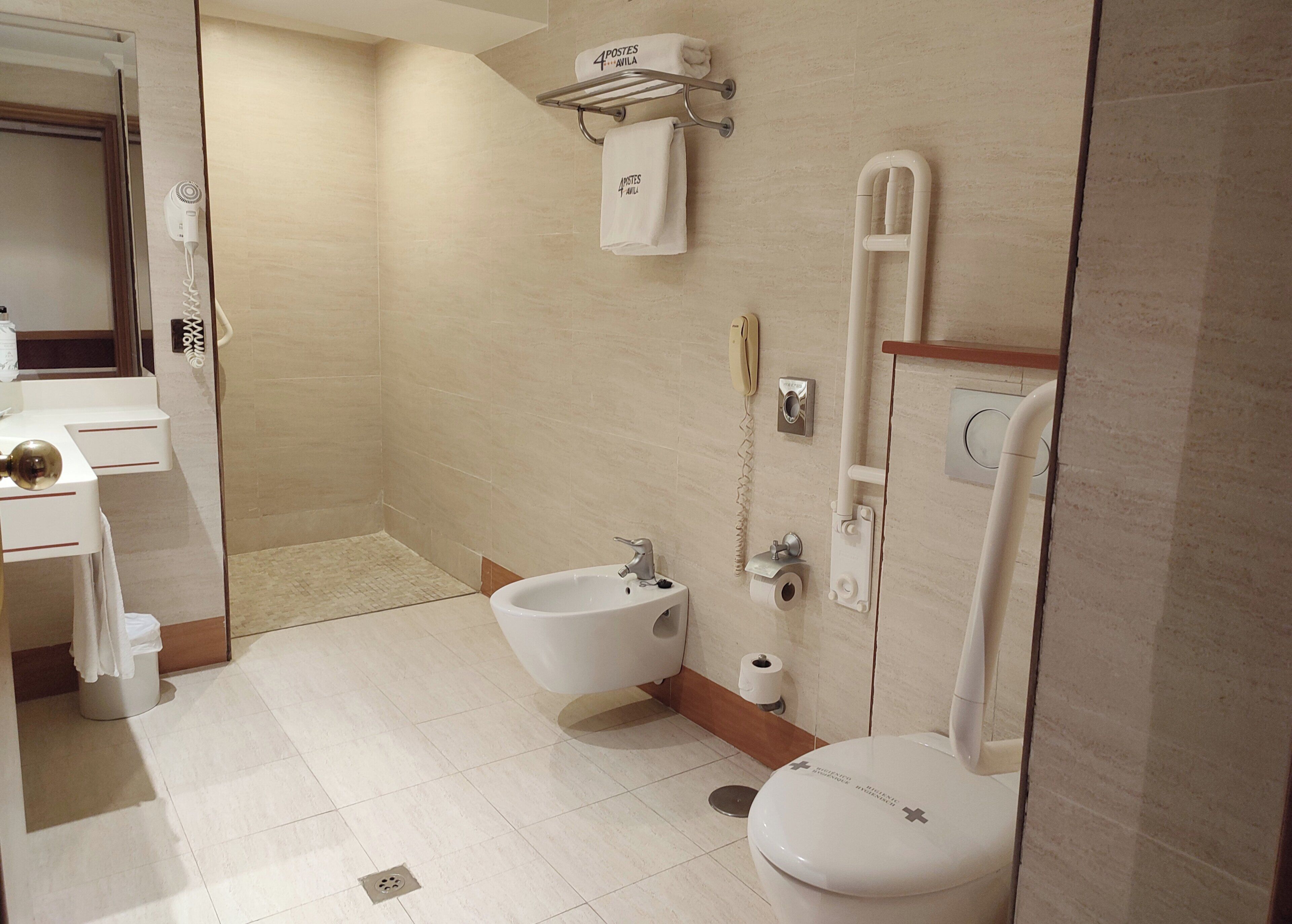Un baño moderno con bidé, inodoro y lavamanos.