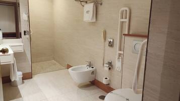 Un baño moderno con bidé, inodoro y lavamanos.