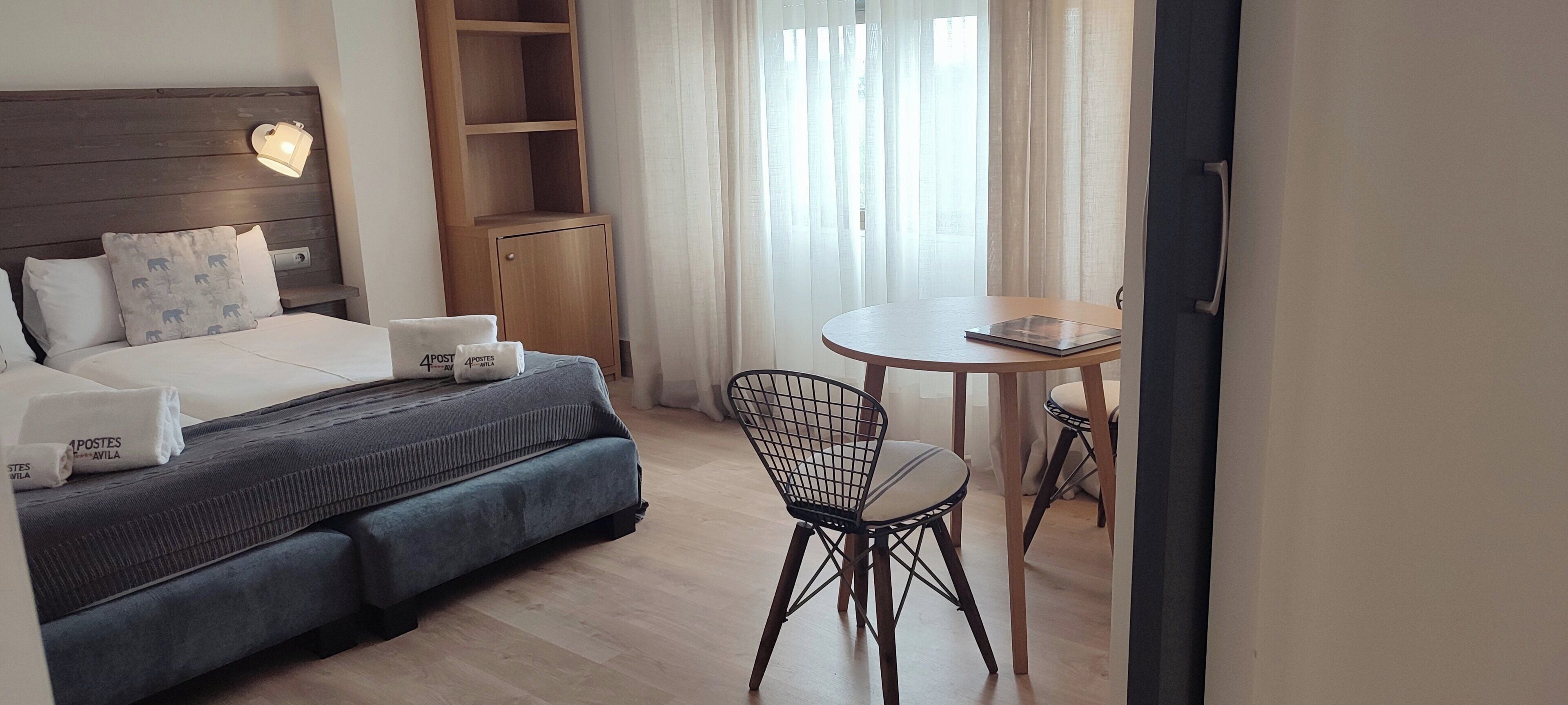 Una habitación de hotel con una cama, un escritorio y una silla.