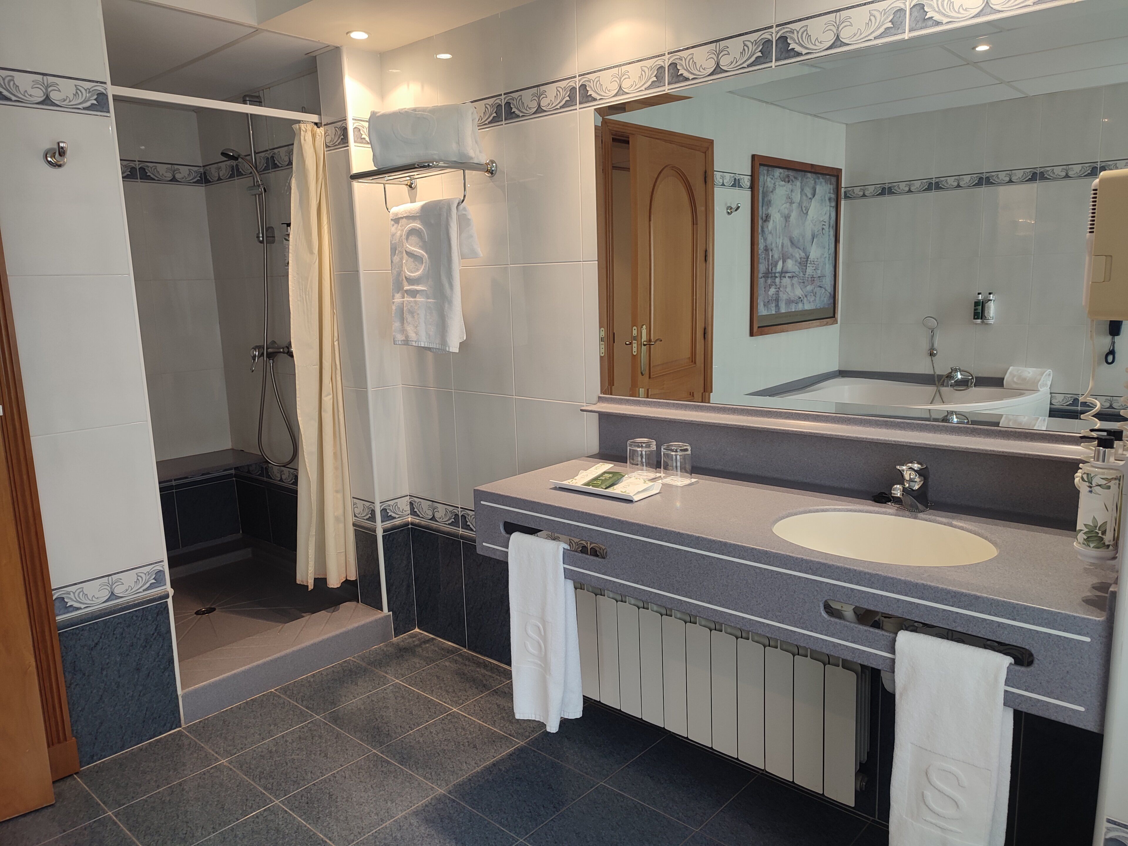 Un baño moderno con ducha, lavabo y tocador.