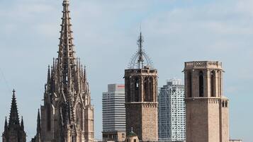 A cathedral with intricate Gothic architecture, a bell tower, and a modern building with a spire.