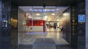A hotel entrance with a glass door, a visible reception desk, and a sign indicating the hotel's name. - Hotel Turin  Barcelona  (Barcelona)