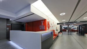 A modern hotel reception area with a prominent red and white color scheme, a reception desk, and directional signage. - Hotel Turin  Barcelona  (Barcelona)