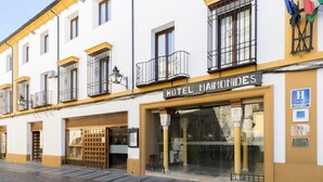 A hotel facade with a sign reading "HOTEL MAMONIDES," featuring balconies, a large glass entrance, and a cobblestone street. - Eurostars Maimónides Hotel (Córdoba)