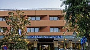 Et hotel med et skilt, der siger "HOTEL ALIXARES", og et parkeringstegn.