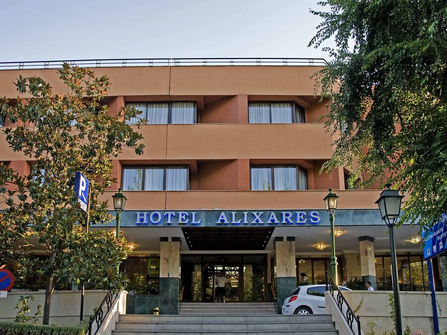 Un hotel con un cartel que dice 'HOTEL ALIXARES' y una señal de estacionamiento.