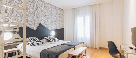 Una habitación de hotel moderna con una cama grande, mesitas de noche, un escritorio y una silla.