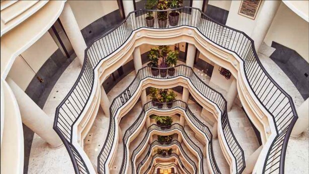 A multi-level atrium with a central open space surrounded by balconies. - Occidental León Alfonso V (León)