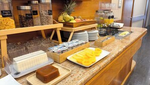 Un bufé de desayuno con diversos alimentos y acompañamientos.