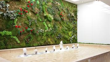 Una pared decorada con diversas plantas y una fuente de agua.