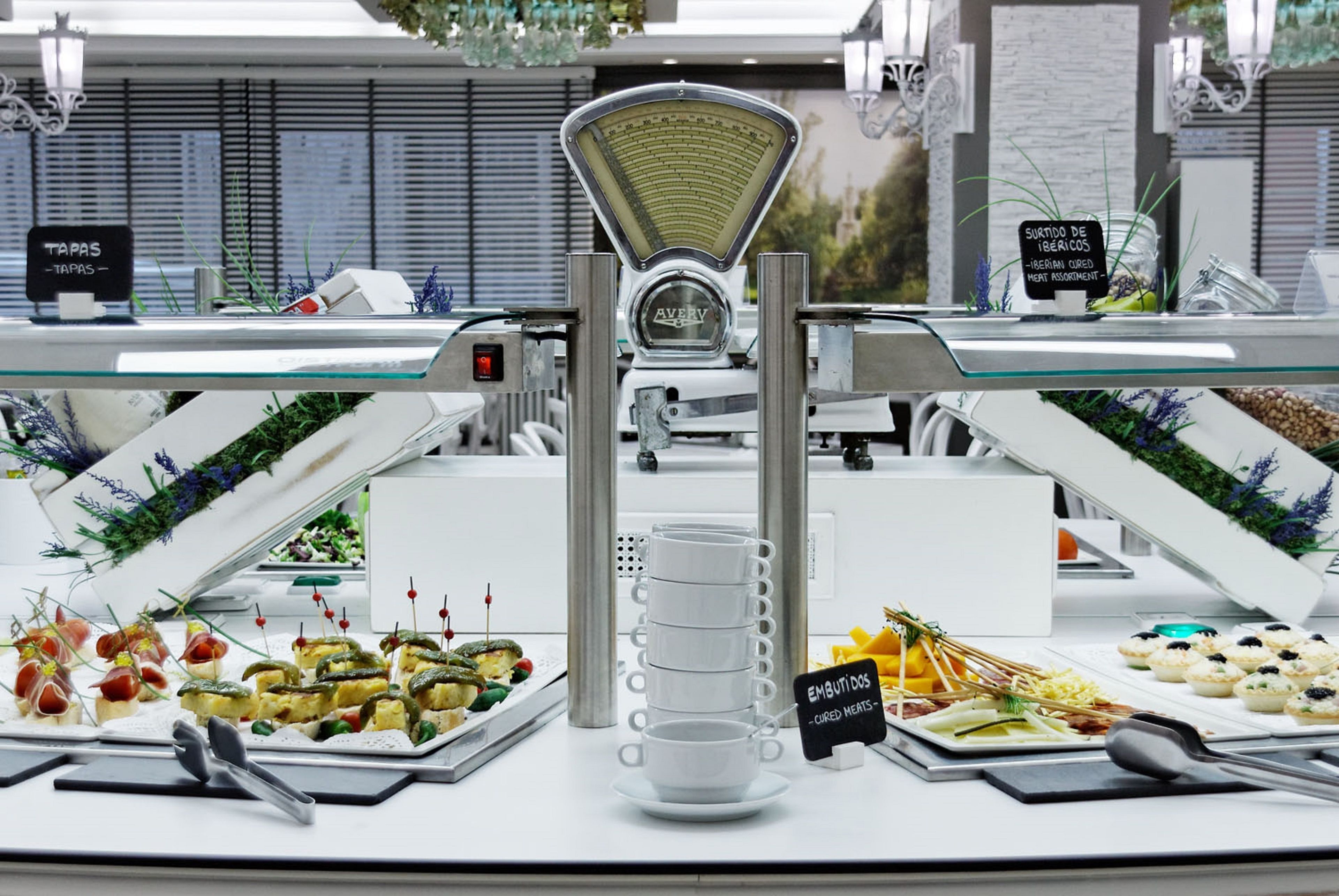Disposição de buffet com diversos alimentos e uma balança.