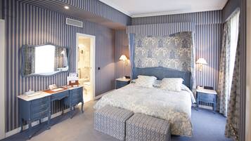 Ein Schlafzimmer mit einem großen Bett, einem Schminktisch, einem Spiegel und einem Nachttisch.