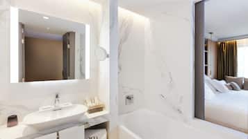A modern bathroom with a marble sink, a large mirror, and a bathtub.