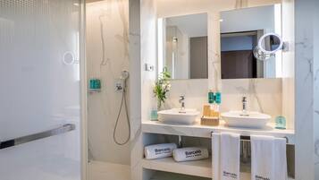 Un baño moderno con dos lavamanos, un espejo grande y una zona de ducha.