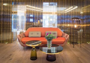 A modern interior with a sofa, two side tables, and a decorative vase.