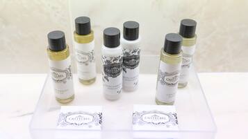 Presentación de los servicios del hotel, incluyendo botellas de crema corporal, champú y gel de baño Castelbel.
