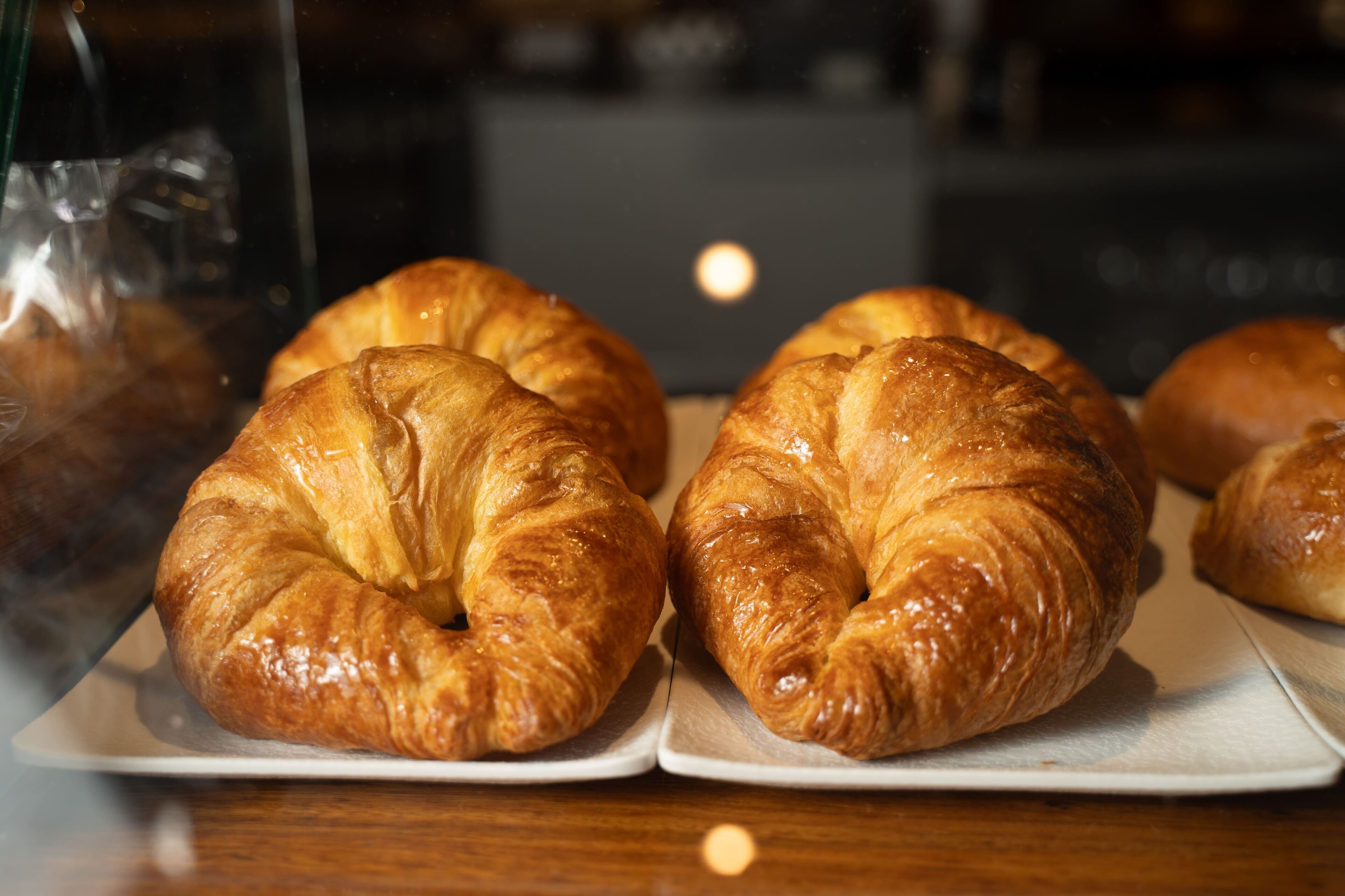 Una bandeja con croissants sobre platos blancos.