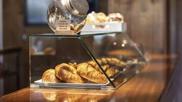 A display case with pastries and a jar labeled "Cookies Caseras con Pepitas de chocolate".