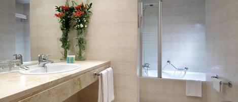 A modern bathroom with two sinks, a shower, and a large mirror.