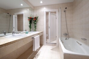 Un baño moderno con dos lavamanos, ducha e inodoro.