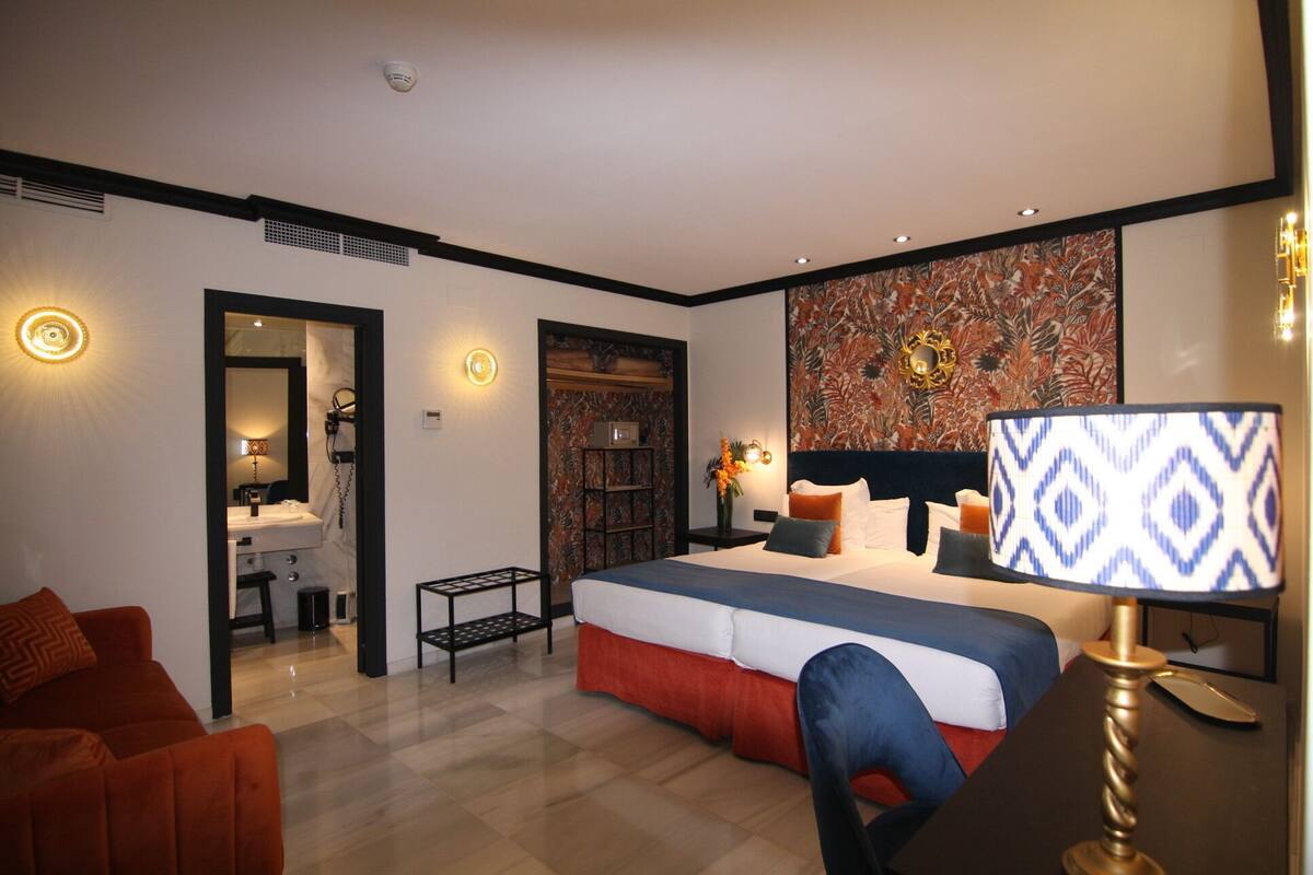 Une chambre d’hôtel moderne, dotée d’un grand lit, d’un bureau, d’une chaise et d’un canapé.