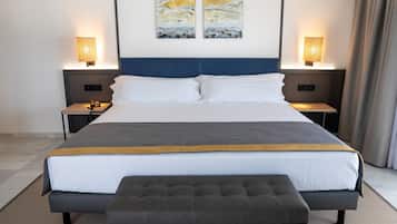 Une chambre d’hôtel moderne avec un grand lit, deux tables de chevet, un banc et des œuvres d’art abstraites accrochées au mur.
