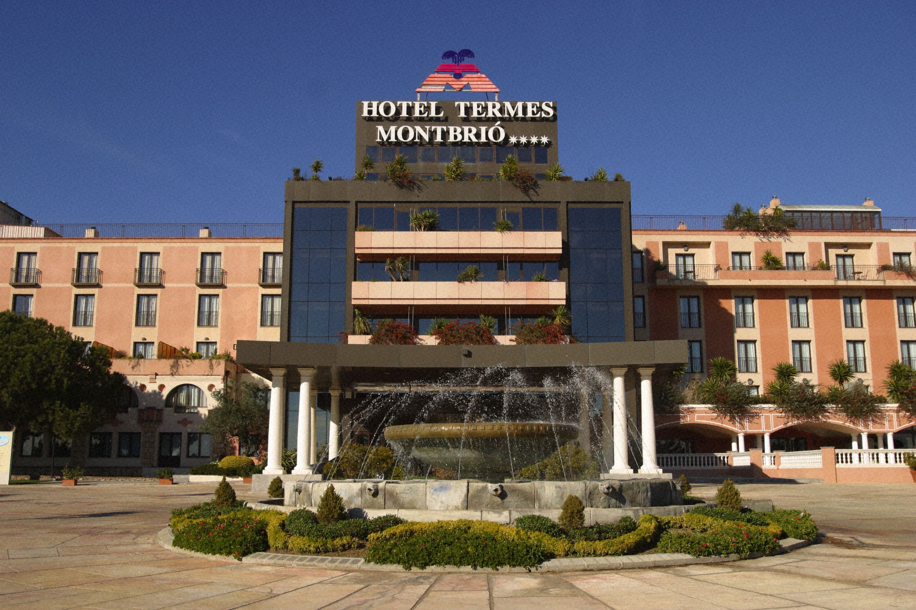 Een hotel met een fontein ervoor, genaamd 'Hotel Termes Montbrío'.