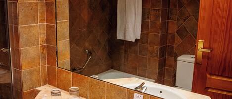 Un baño con un lavamanos grande, espejo y ducha.