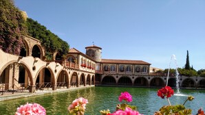Un bâtiment historique doté d’arcades et d’une fontaine.