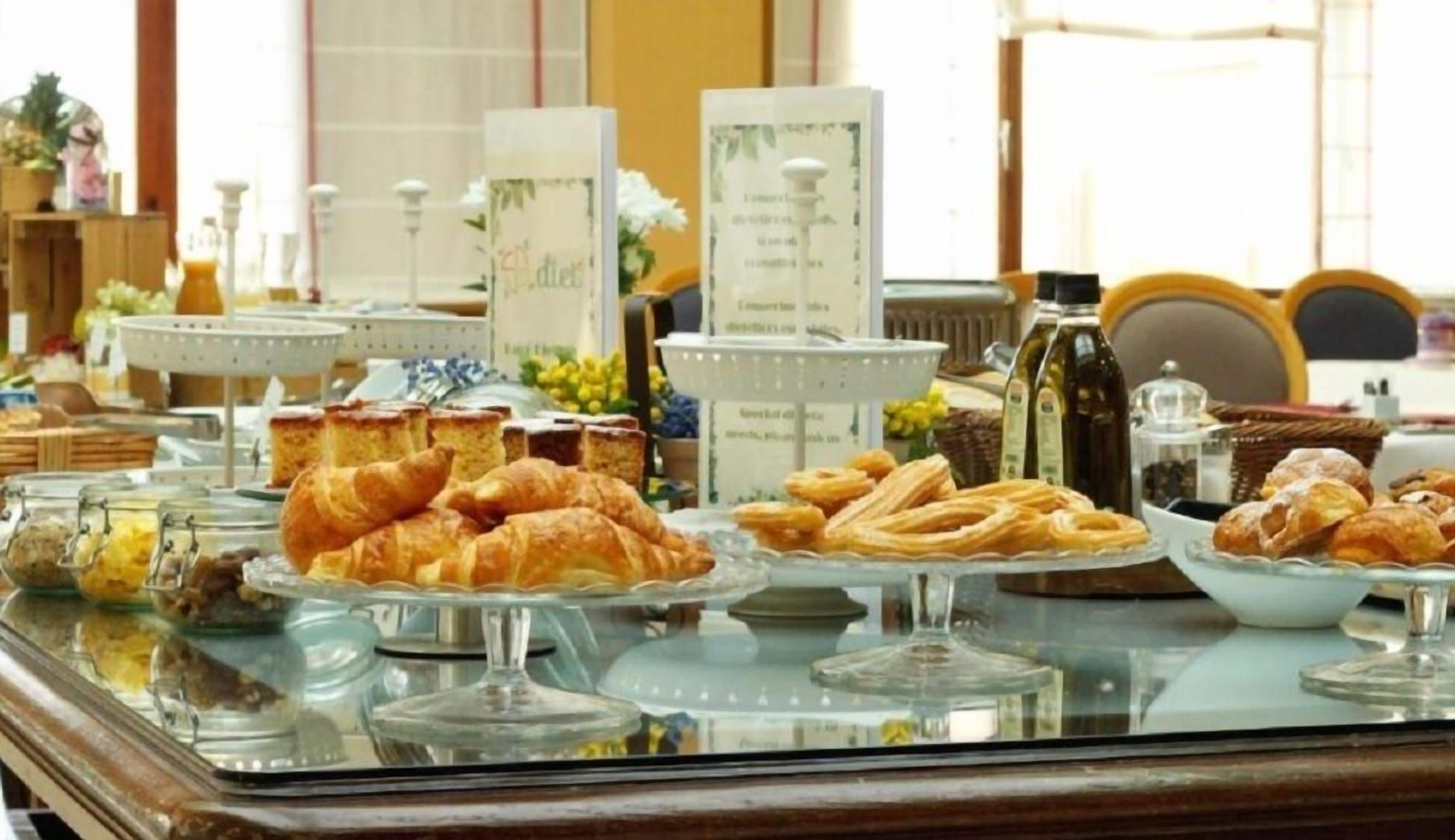 Un buffet proposant diverses pâtisseries et un tableau affichant le menu.