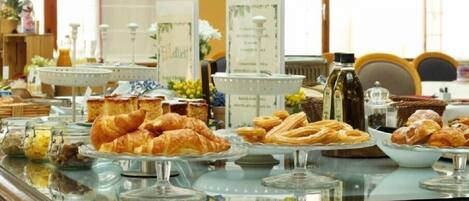 A buffet with various pastries and a menu board.