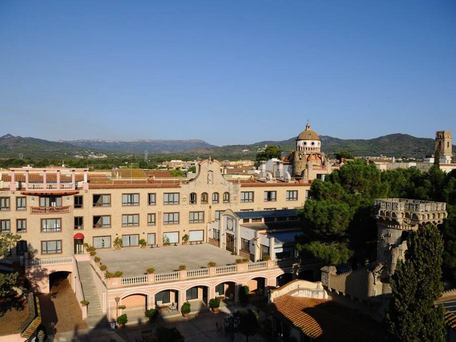 A historic building with a central courtyard, a dome, and a tower.