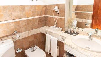 Un baño con inodoro, lavamanos y barra para toallas.