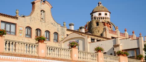 Un edificio histórico con una torre distintiva y ventanas en arco.