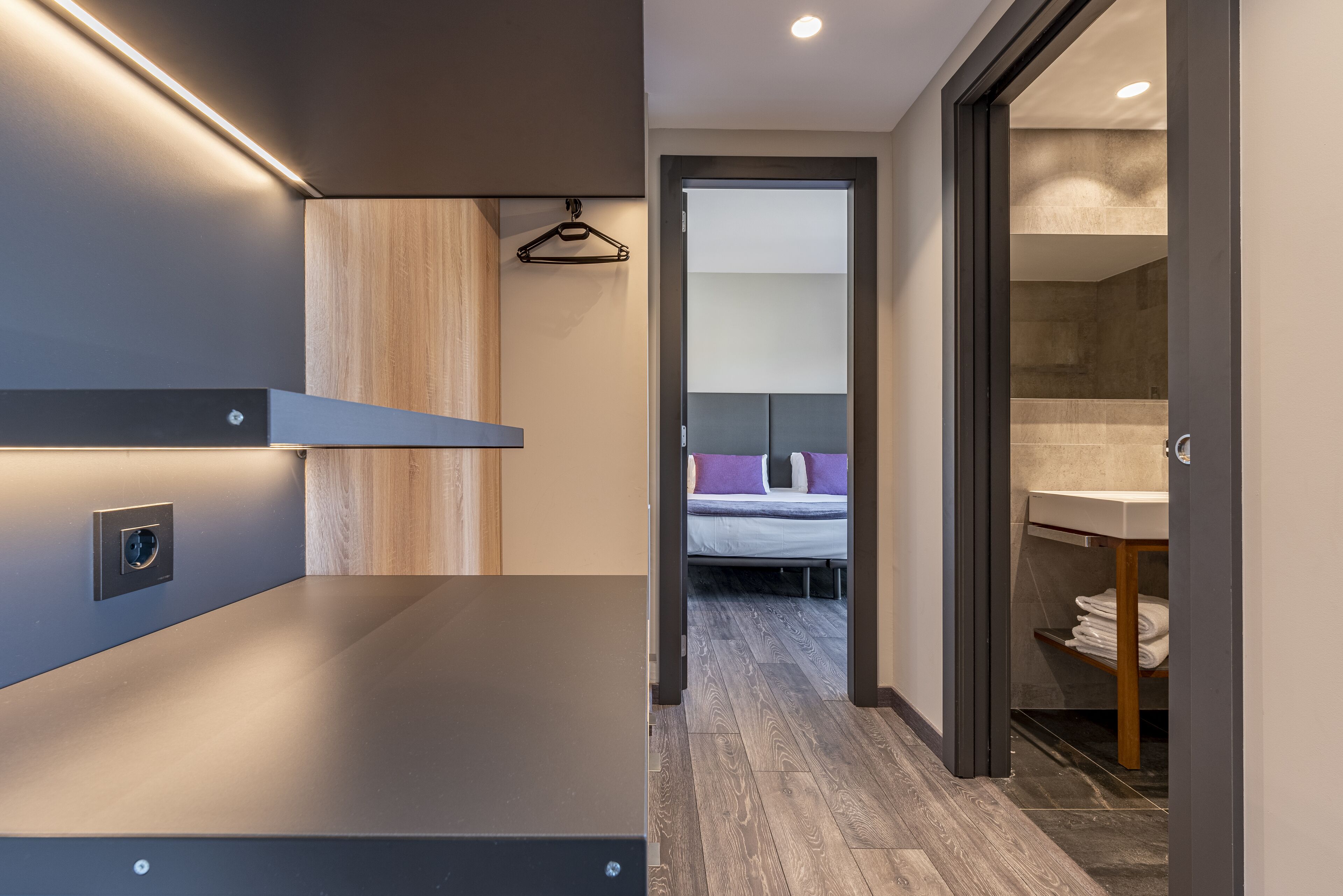 Un baño moderno con un espejo grande, un lavabo y una zona de ducha.