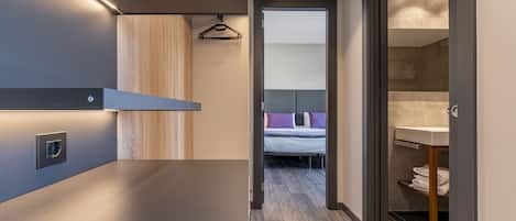 Un baño moderno con un espejo grande, un lavabo y una zona de ducha.