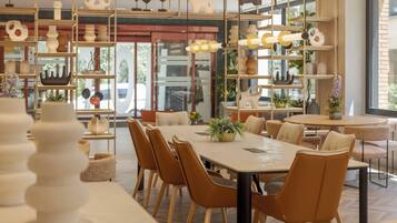 A modern dining area with a large table, multiple chairs, and decorative shelves with various items.