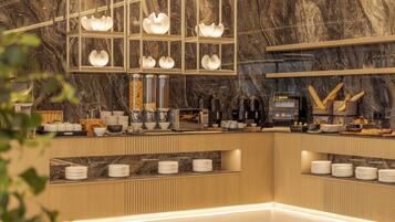 A modern kitchen with marble countertops, a coffee machine, and neatly arranged plates and bowls.