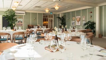 A restaurant with multiple tables set for dining, each with wine glasses and cutlery.