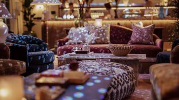 A cozy lounge area with plush seating, a coffee table, and ambient lighting.