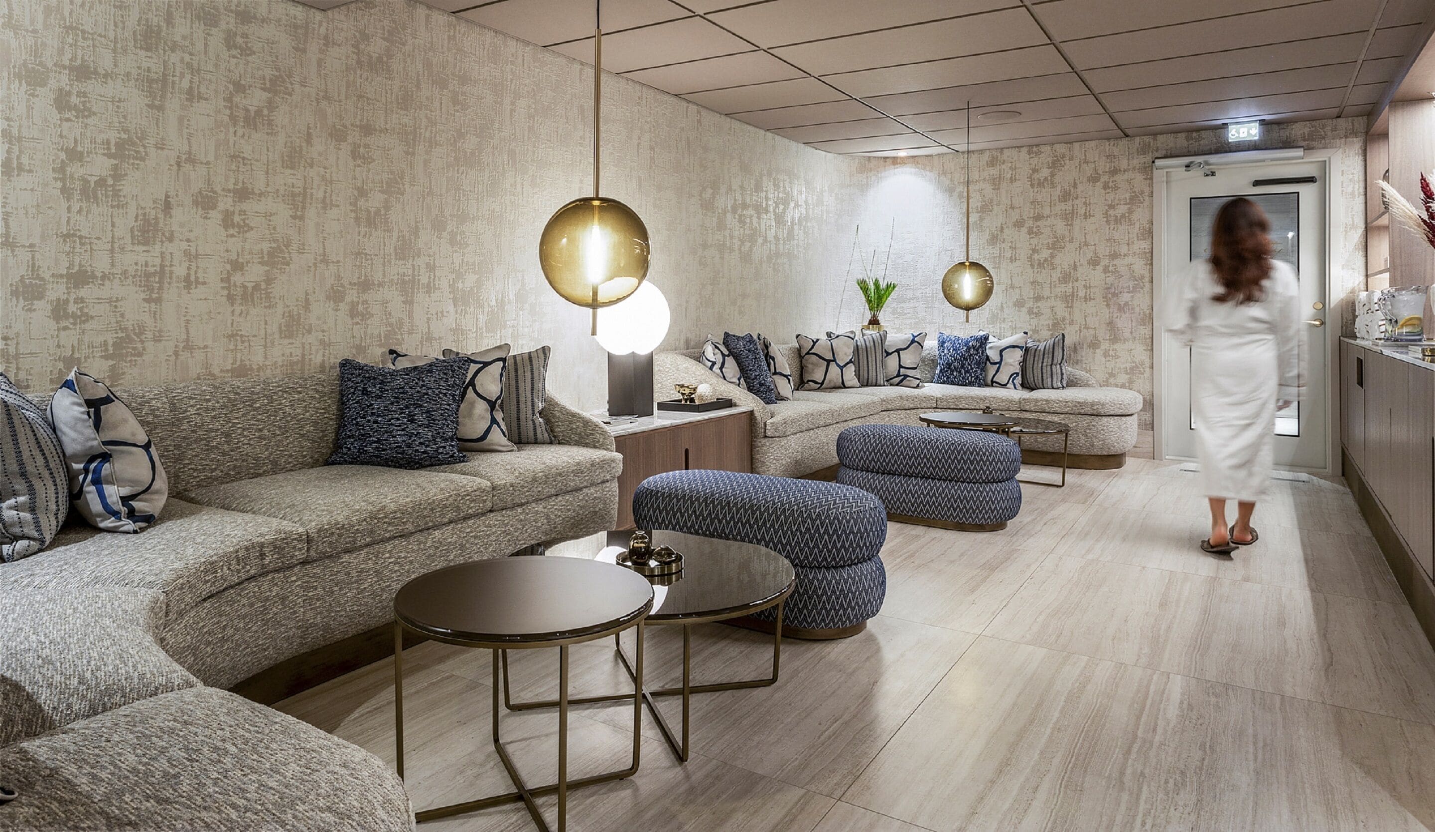 Una sala de estar moderna con un sofá modular, otomanas, una mesa de centro e iluminación colgante.